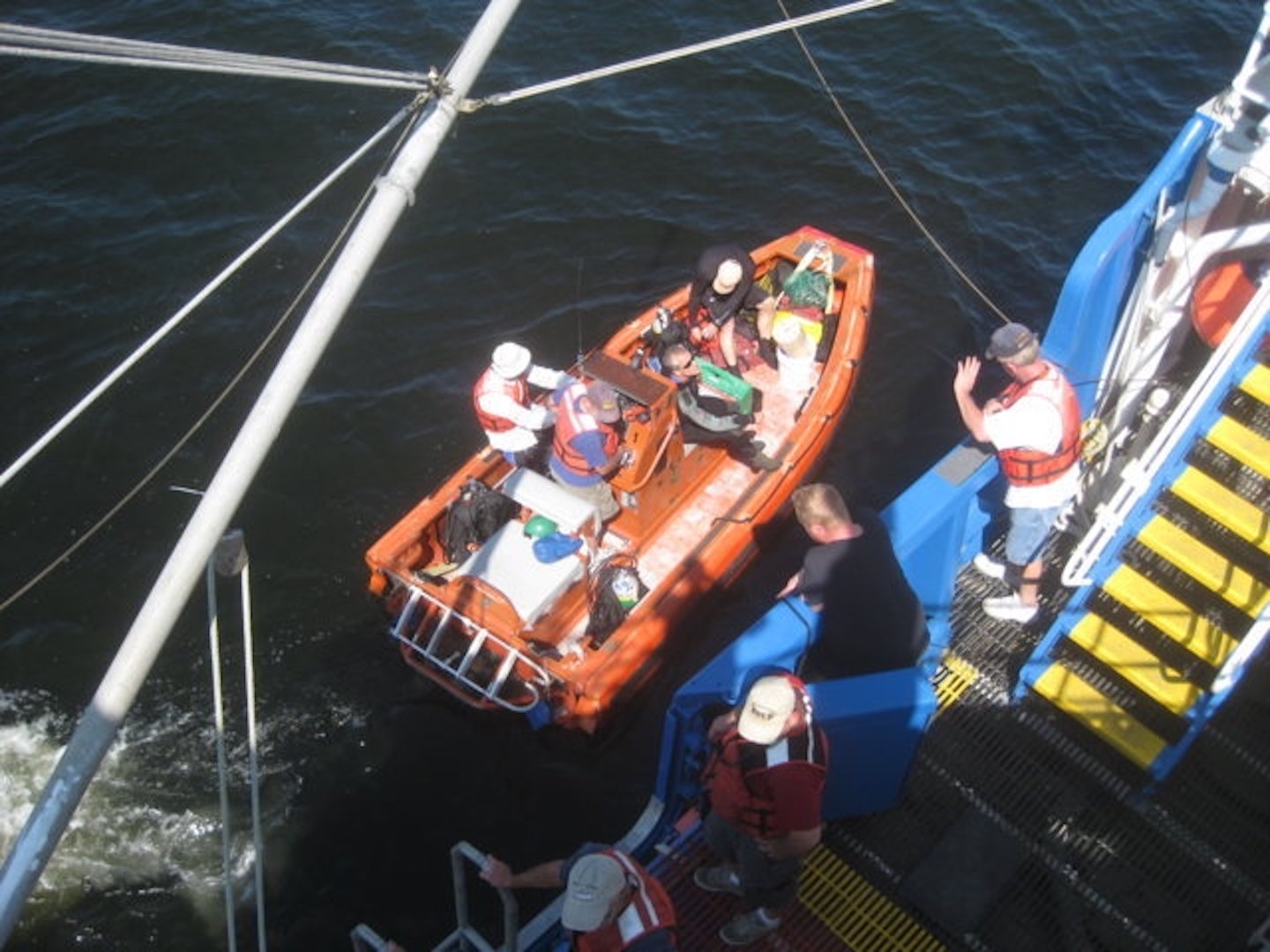 Field team members boarding a boat for site designation studies.