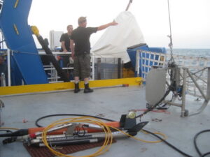 Field team members working with equipment shown in foreground.