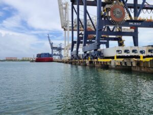 Teammates moving equipment onto boat in San Juan Harbor