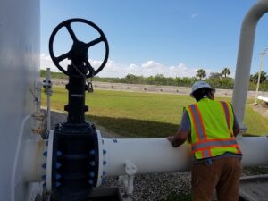 Picture of pipes and tanks on MacDill AFB with field work teammate.