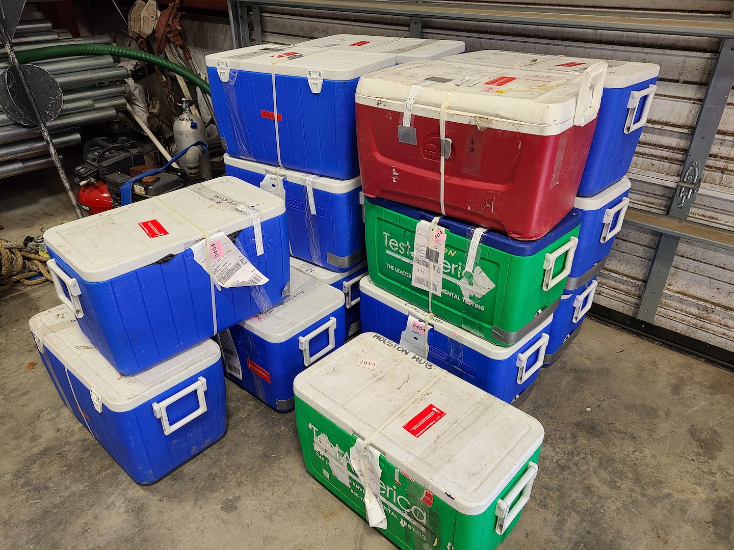 Multiple coolers stacked containing sediment from field work.