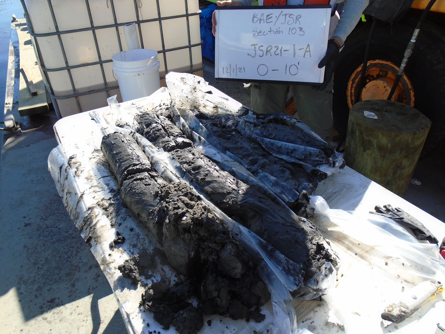 Core Samples from field work on display on top of table with information about place of sampling on display in background.