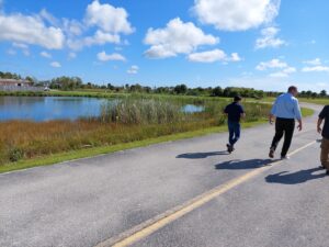 Group walking project area with blue sky and marshy area to the group's left.